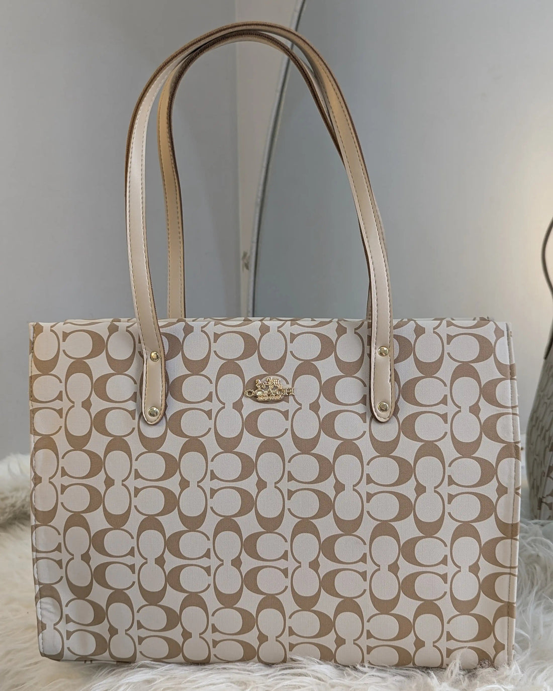 Beige handbag with a pattern on a light gray background