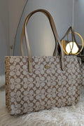 Beige handbag with a pattern on a white surface