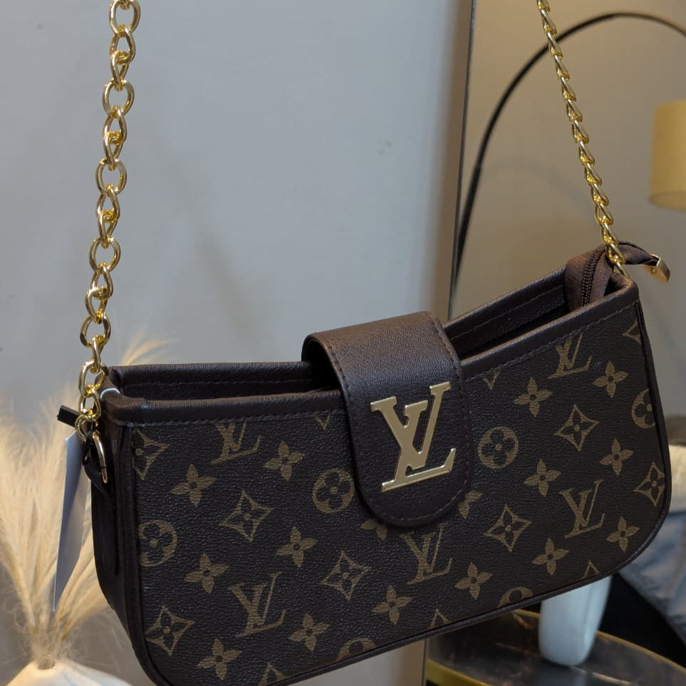 Designer handbag with monogram pattern and gold chain strap on a neutral background